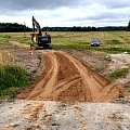 "Valmieras ceļi" ekskavators strādā pie grants ceļa būvniecības lauka Vidzemē